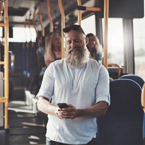 Mann im Bus schaut entspannt auf sein Smartphone