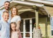 Glückliche Familie vor Effizienzhaus 40, das vom Staat gefördert wurde.