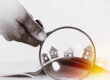Paper house under a magnifying lens; Immobilienkauf